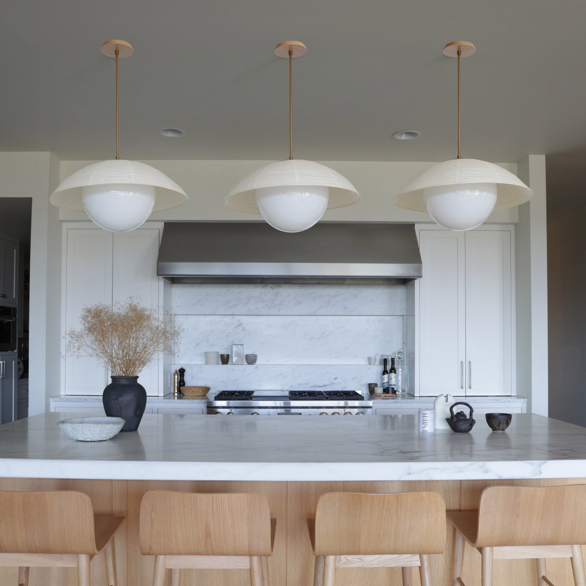Maru Pendants with Natural shades shown in Heirloom Brass with a Maple Wood canopies