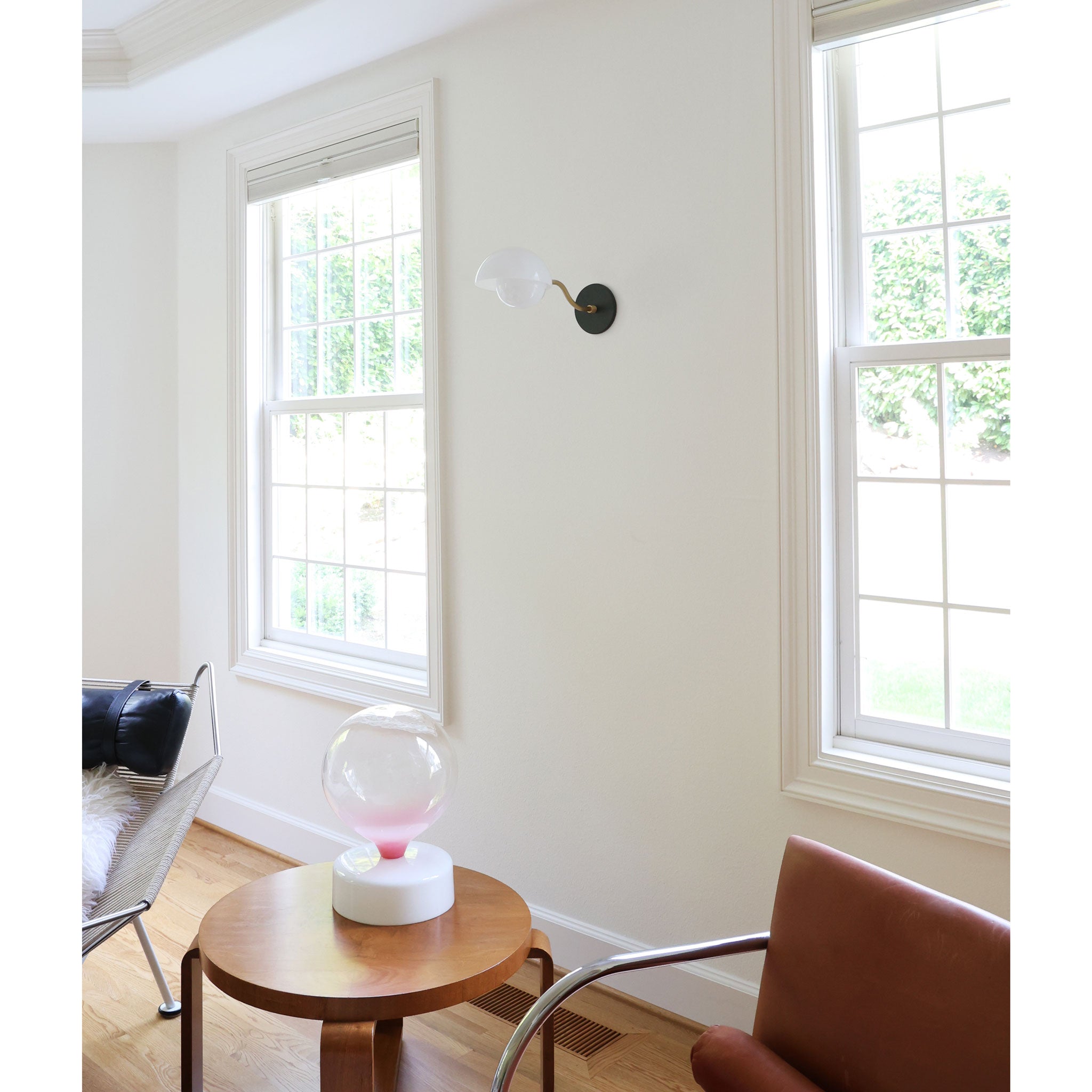 Noor Curve Sconce shown with a White Opal Acrylic Shade, Heirloom Brass Arm and Matte Black Canopy