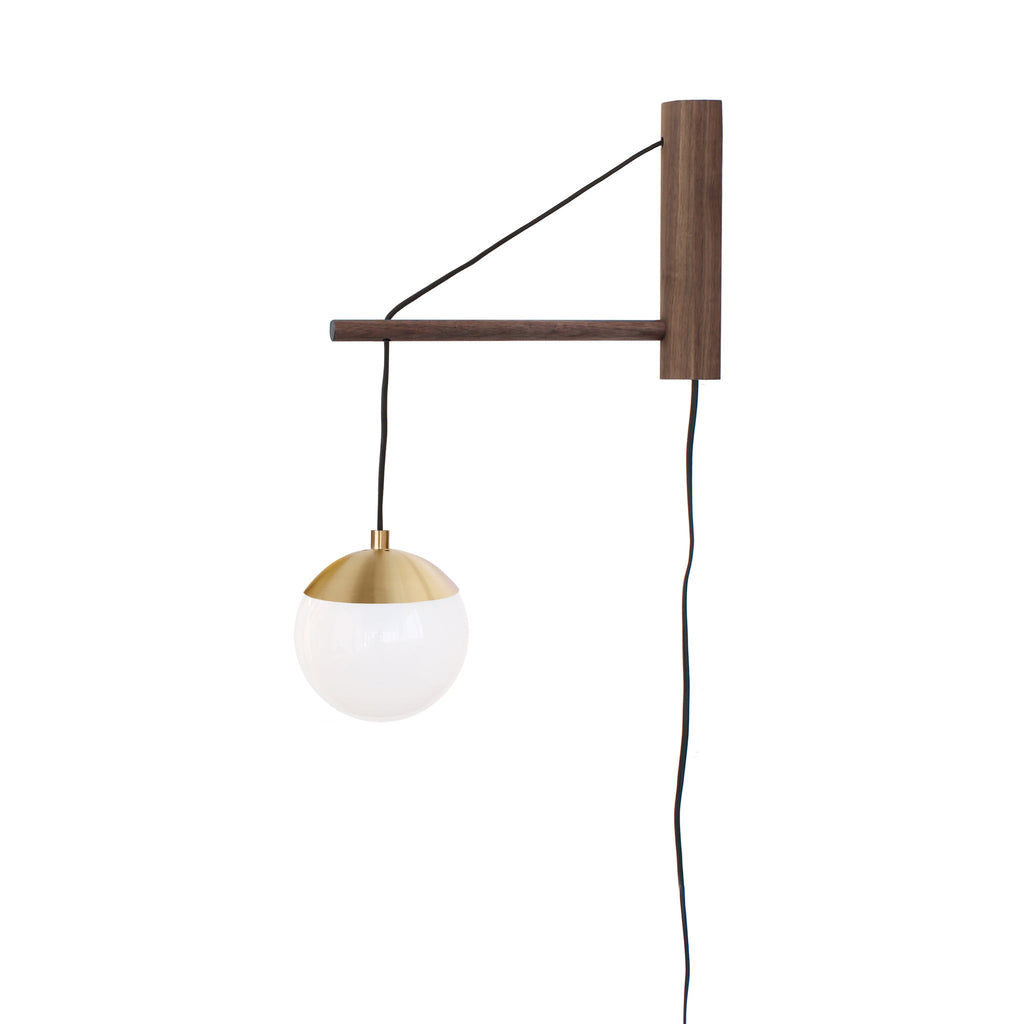Alto 14" Wood Arm Sconce shown in Brass with Walnut, a 6" Opal globe, and a Black Plug-in Cord.