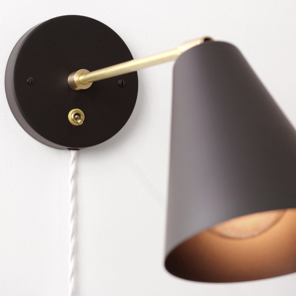 Tilt Cone shown in Matte Black with Brass finish with 9" arm and Brass switch and White cord.