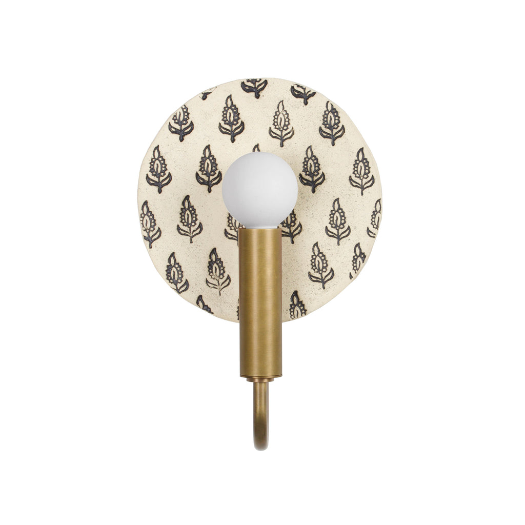Edith ADA Sconce shown in Heirloom Brass with a Black and Cream Floral ceramic backplate.
