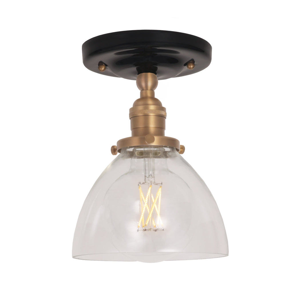 Grace Surface shown in Heirloom Brass with a Gloss Black Ceramic canopy and Clear Glass shade