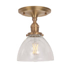 Grace Surface shown in Heirloom Brass with a Clear Glass shade
