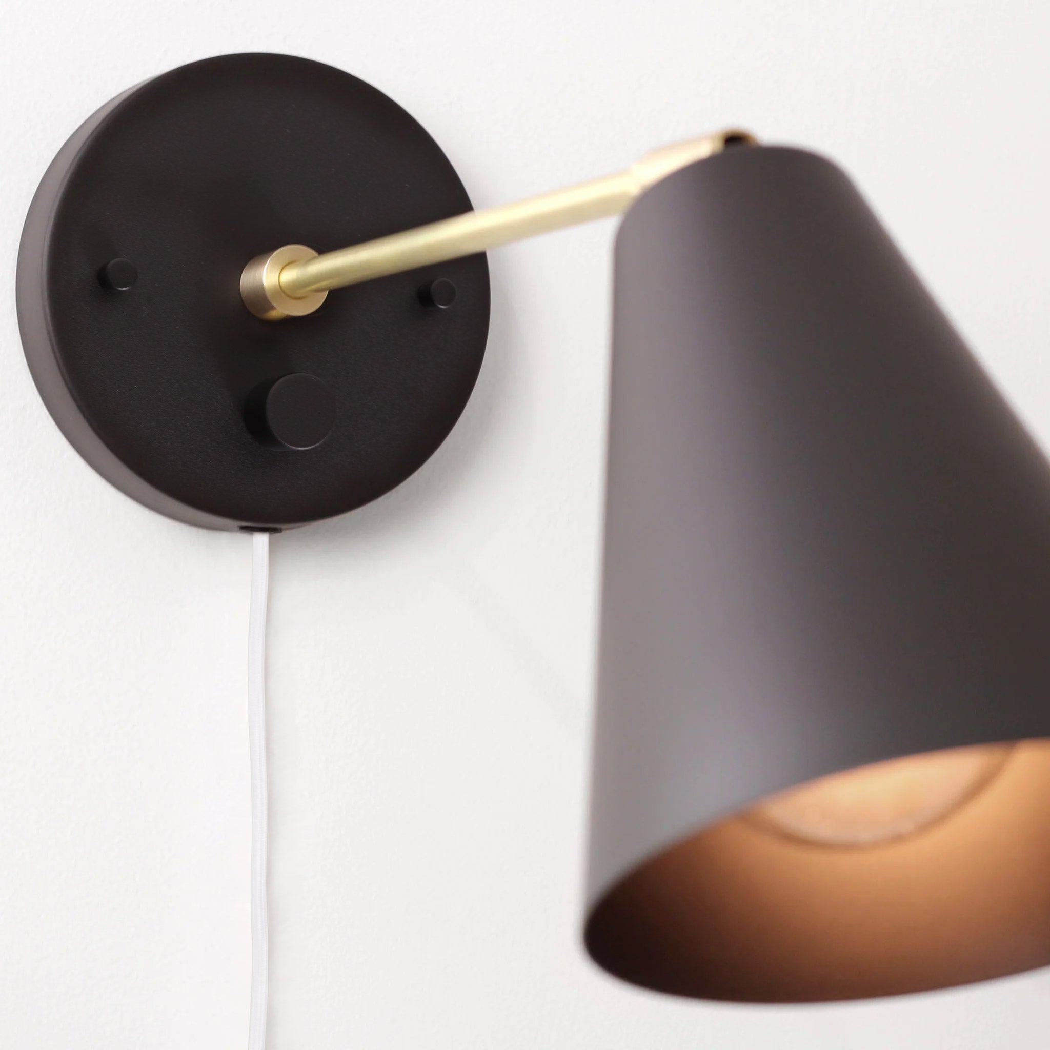 Tilt Cone shown in Matte Black and Brass with a 9" arm, Backplate Dimmer Switch and White Cord