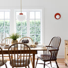 Pearl Sconce in Persimmon with a Anni Large Pendant shown with a Brass rod and canopy and Persimmon accent finish