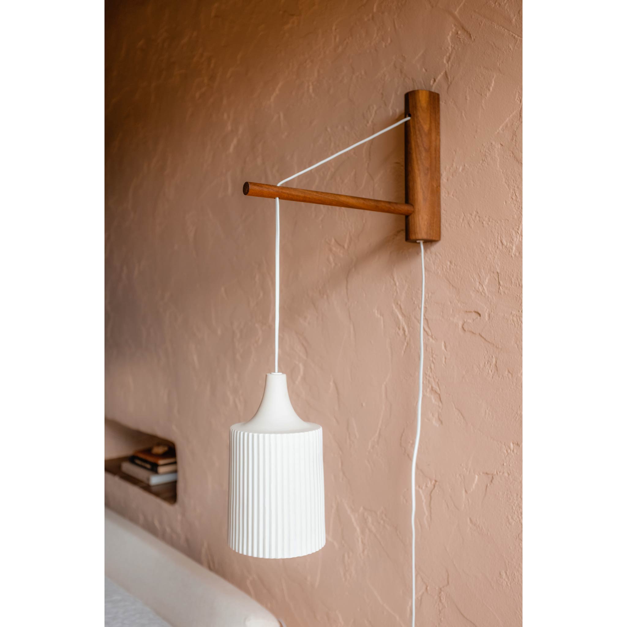 Tumwater 14" Wood Arm Sconce shown in Walnut with a White Plug-in Cord. Photo by Posada Inn by The Joshua Tree House