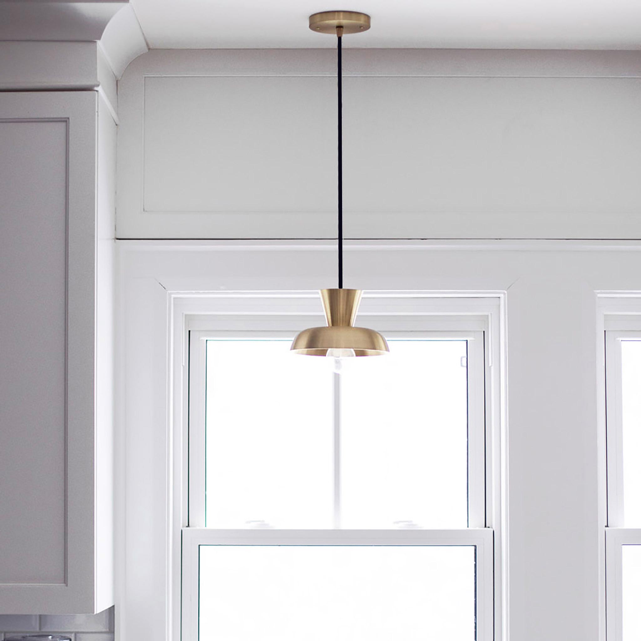Isle Cord Pendant shown in Brass with a Black Cloth Cord. Interior Design by Marcella DiLonardo