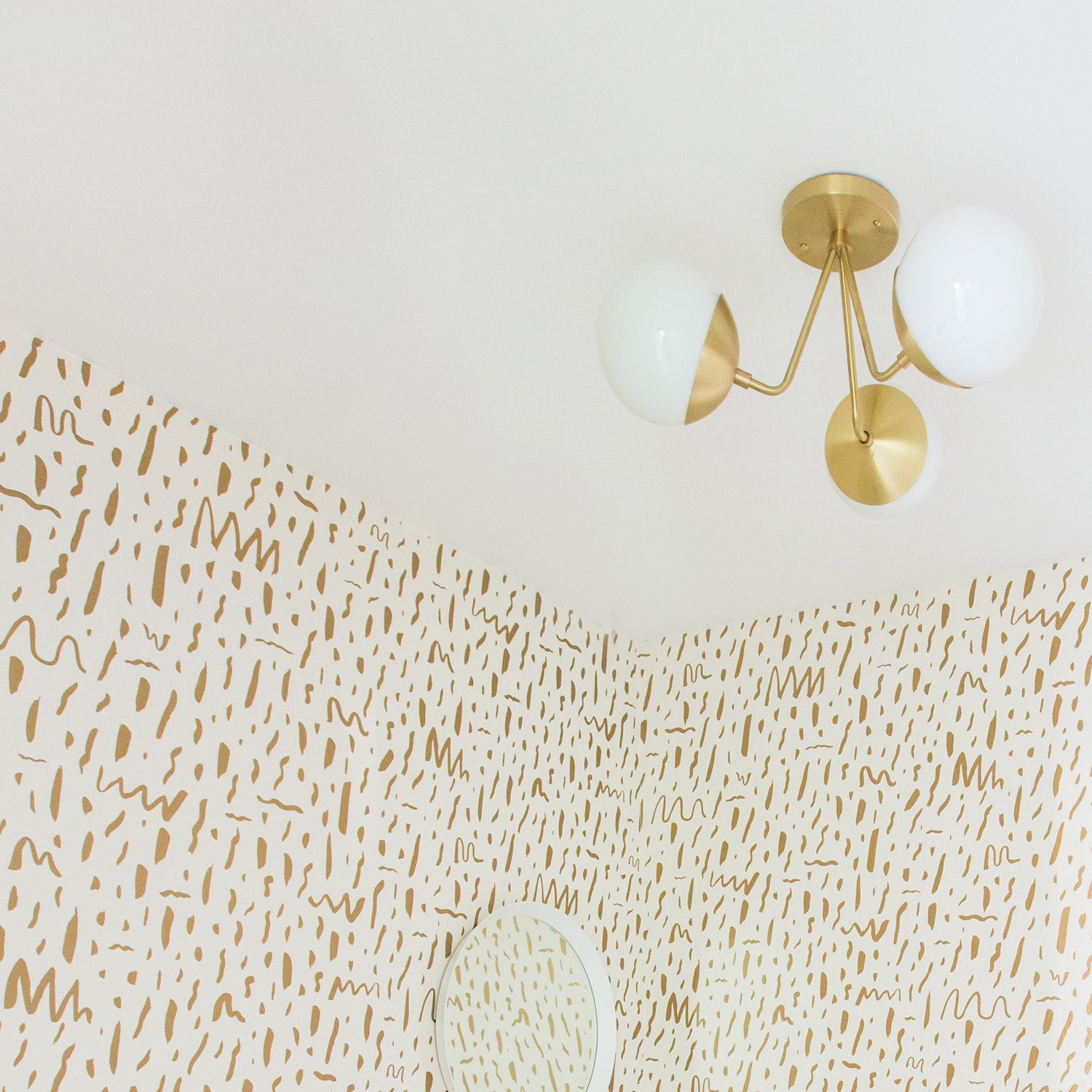 Trillium shown in Brass with 6" Opal globes. Interior Design by Joy Cho